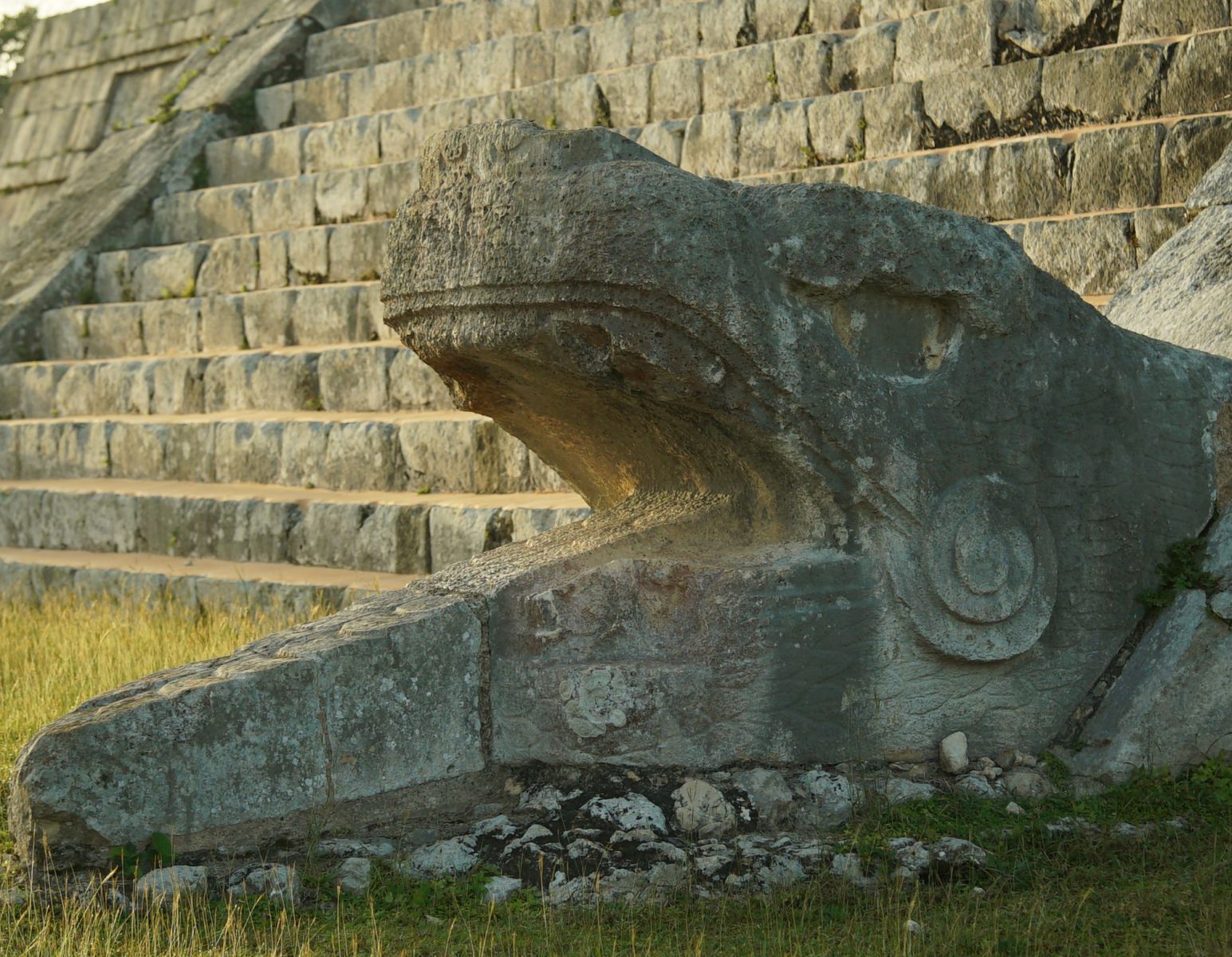 A stone serpent head at the foot of Kukuulkaan’s staircase